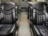 This rv rental features a luxurious van interior with two comfortable black leather captain's chairs, leading to a rear lounge area.