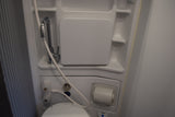 Compact RV rental wet bath with toilet, shower, and fold-down sink for efficient space.