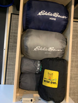 Optimized **RV rental** storage: Packed Eddie Bauer, HiHiker, and Wise Owl Outfitters outdoor gear in a wood drawer.