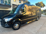 Sleek black Mercedes-Benz Sprinter conversion van, ideal for an RV rental, parked on a sunny driveway.