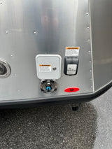 RV rental exterior showing water and SmartPlug electrical inlets, plus a hot water vent. Safety warnings are prominent.