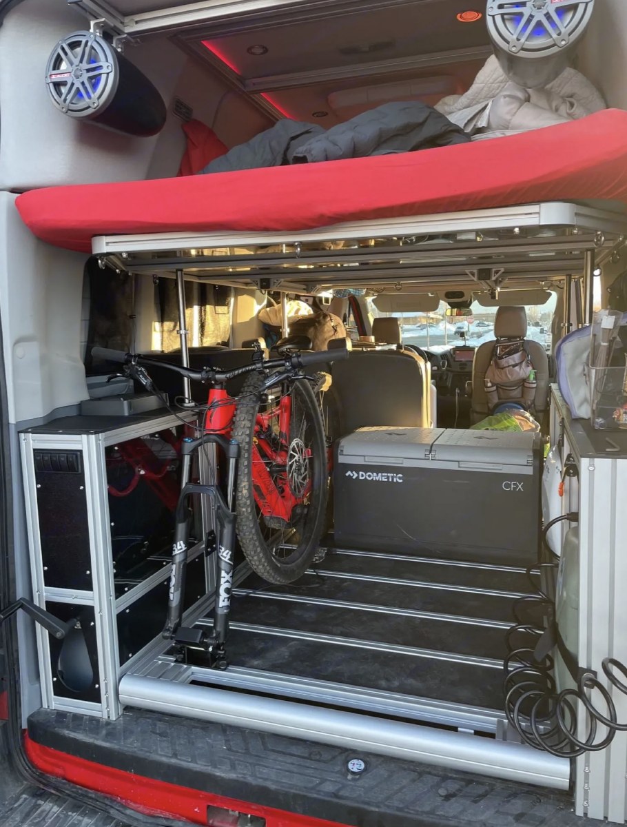 Adventure-ready RV rental: built-in bike mount, bed, and fridge inside a spacious camper van.