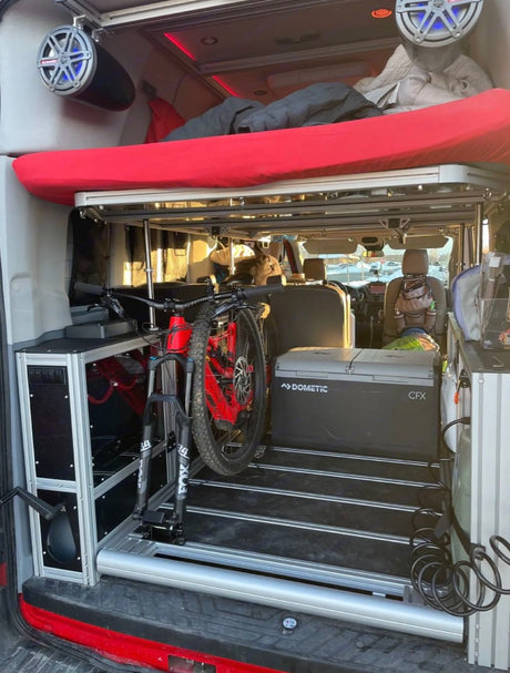 Adventure-ready RV rental: built-in bike mount, bed, and fridge inside a spacious camper van.