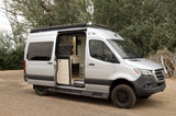 Explore with this silver Mercedes Sprinter camper van RV rental, showcasing its custom interior with kitchenette. Perfect for adventure!