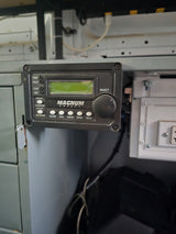 rv rental: Magnum Energy inverter/charger control panel inside an RV, showing power, charge, and inverter status for off-grid use.