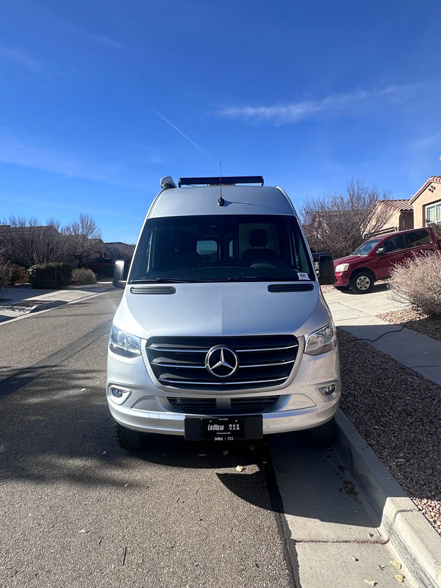  parked on a sunny residential street.|Silver Mercedes-Benz Sprinter van rv rental parked curbside on a sunny day