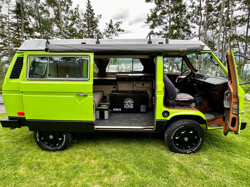  with a blurred mountain view outside.|A vibrant lime green VW Vanagon camper van is parked on green grass. Ideal for an RV rental & outdoor adventures!|Bright lime green VW Vanagon pop-top camper — photo 18