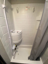 RV rental shower featuring a compact design, handheld spray, corner sink, and shower curtain. Essential for travel.