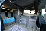 Spacious RV rental interior featuring a convertible bed, compact kitchen area, and storage cabinets. Perfect for travel.
