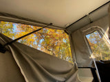 RV rental view from inside a pop-up camper, with vibrant autumn trees through the window.