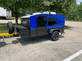 This blue & black Hiker Trailer, a compact teardrop camper, is an ideal RV rental for your next trip.