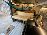 Cozy camper van interior for your next RV rental adventure. Hammock, bed, and kitchenette make it a perfect mobile home.