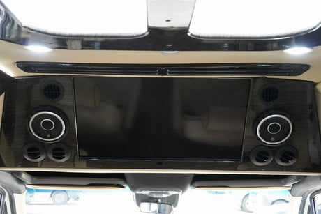RV rental interior: Overhead TV, JL Audio speakers, and air vents offer premium entertainment & climate control.