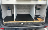 RV rental van's custom interior: organized cargo space with chevron walls, rubber mats, built-in storage, and power system setup.