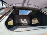 Spacious rooftop tent interior with mattress & scenic views, ideal for your next RV rental adventure.