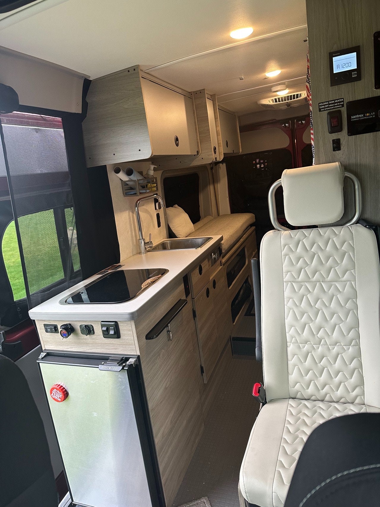  and convertible dining space.|View inside an RV rental showing a compact kitchen with sink/stove — photo 8
