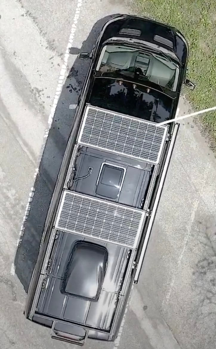 Black RV rental featuring two large rooftop solar panels, perfect for off-grid adventures. See details of this van conversion.