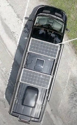 Black RV rental featuring two large rooftop solar panels, perfect for off-grid adventures. See details of this van conversion.