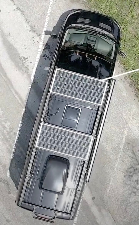 Black RV rental featuring two large rooftop solar panels, perfect for off-grid adventures. See details of this van conversion.