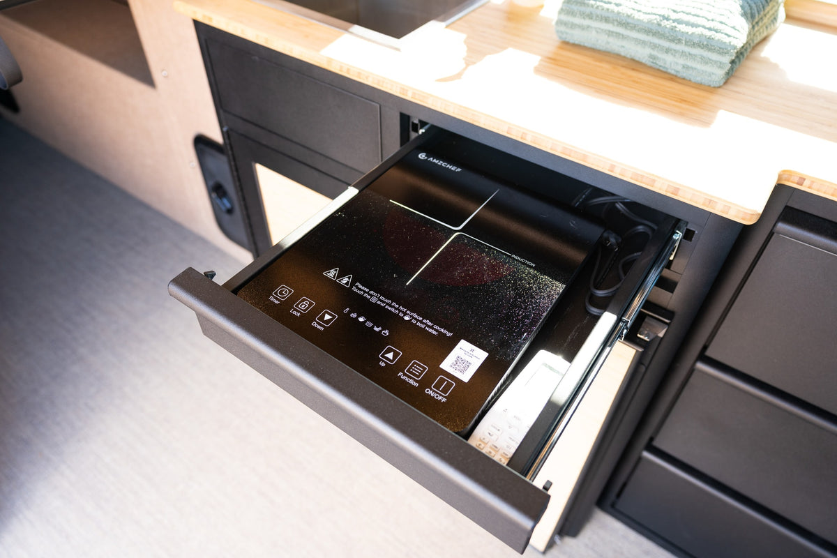This RV rental features a convenient slide-out AMZCHEF induction cooktop with touch controls in a compact kitchen setup. — photo 14