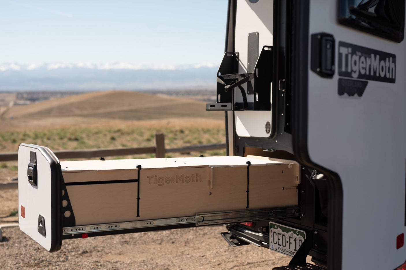 An RV rental's slide-out unit, branded TigerMoth, offers versatile storage/sleeping for outdoor adventures.