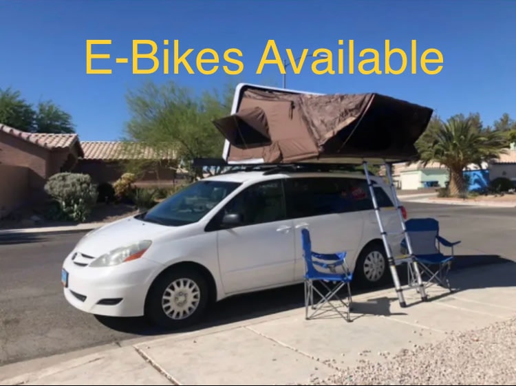 E-Bikes Available! Explore with this white minivan rv rental featuring a rooftop tent