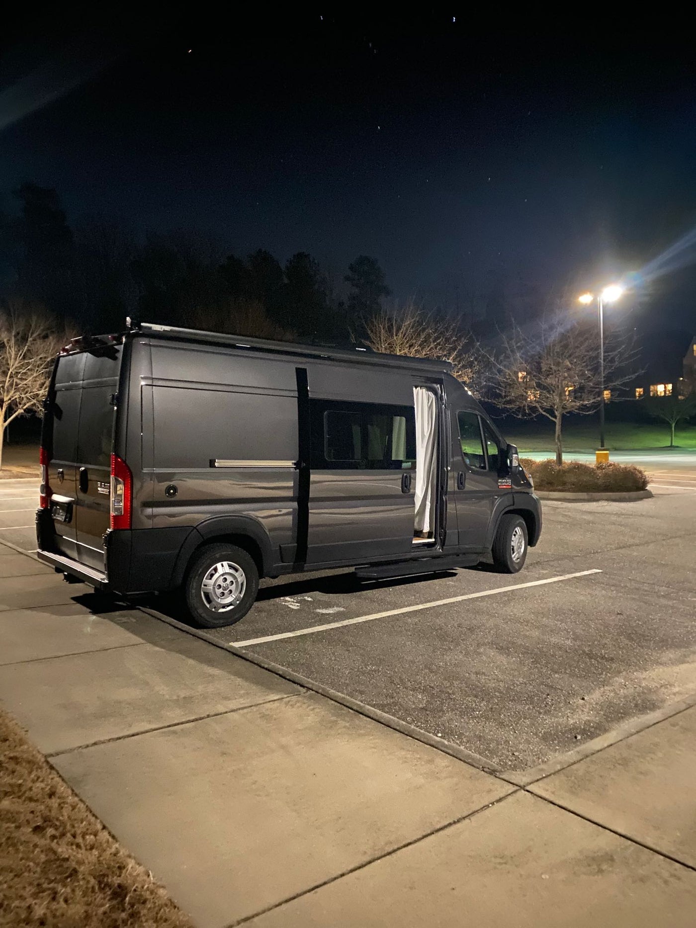 and clever storage solutions.|Cozy RV rental bed with an expansive view of a serene lake
