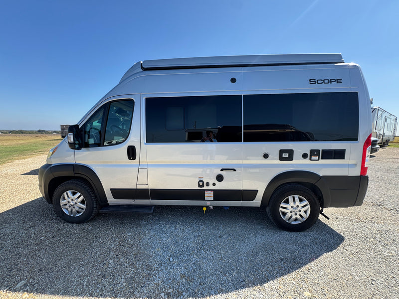 A sleek silver Scope camper van parked on gravel under a clear sky. Perfect for an RV rental getaway. — photo 1
