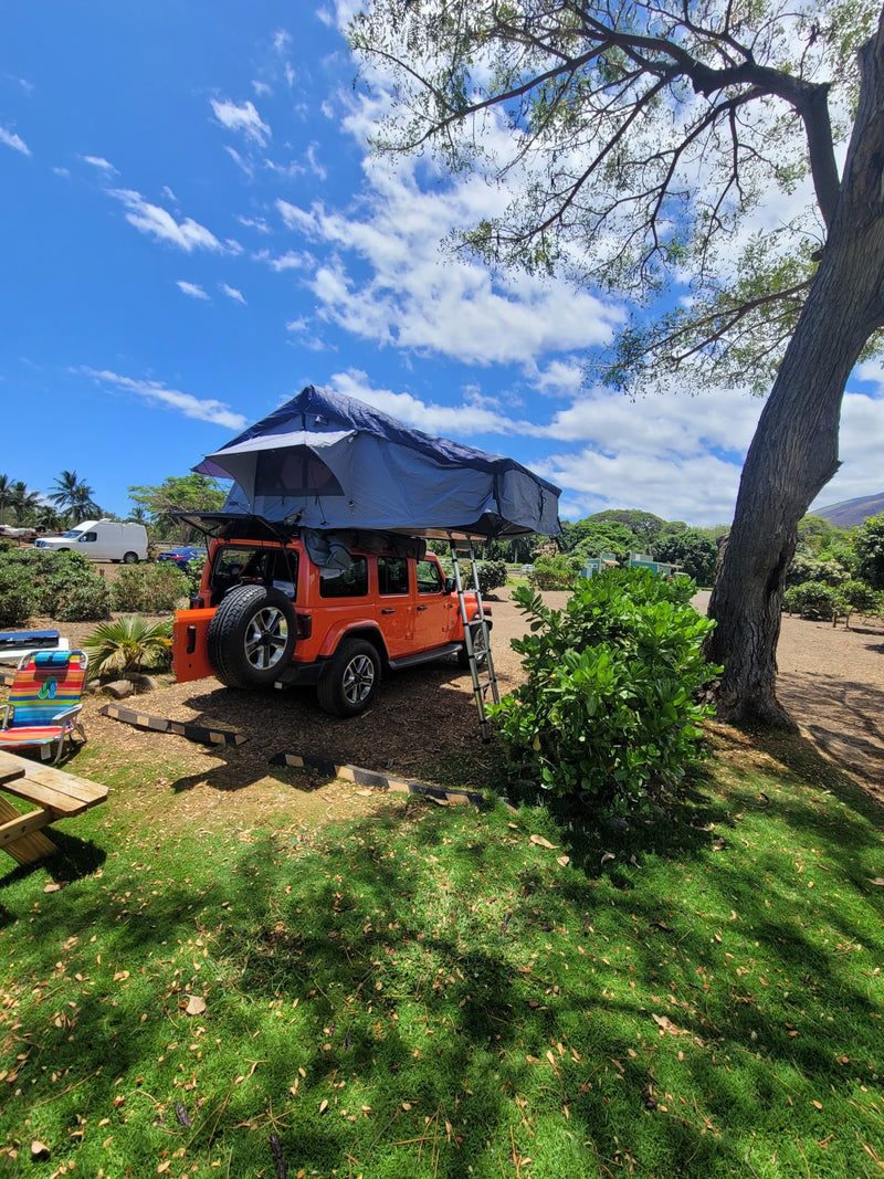 Orange Jeep with rooftop tent deployed; a great rv rental option for camping, with picnic area under sunny sky. — photo 12