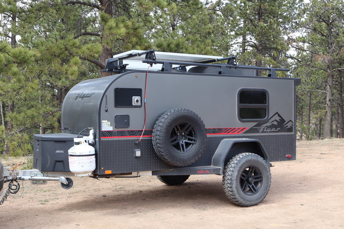 This grey InTech Flyer off-road rv rental is an adventure trailer with solar & rugged tires for camping.