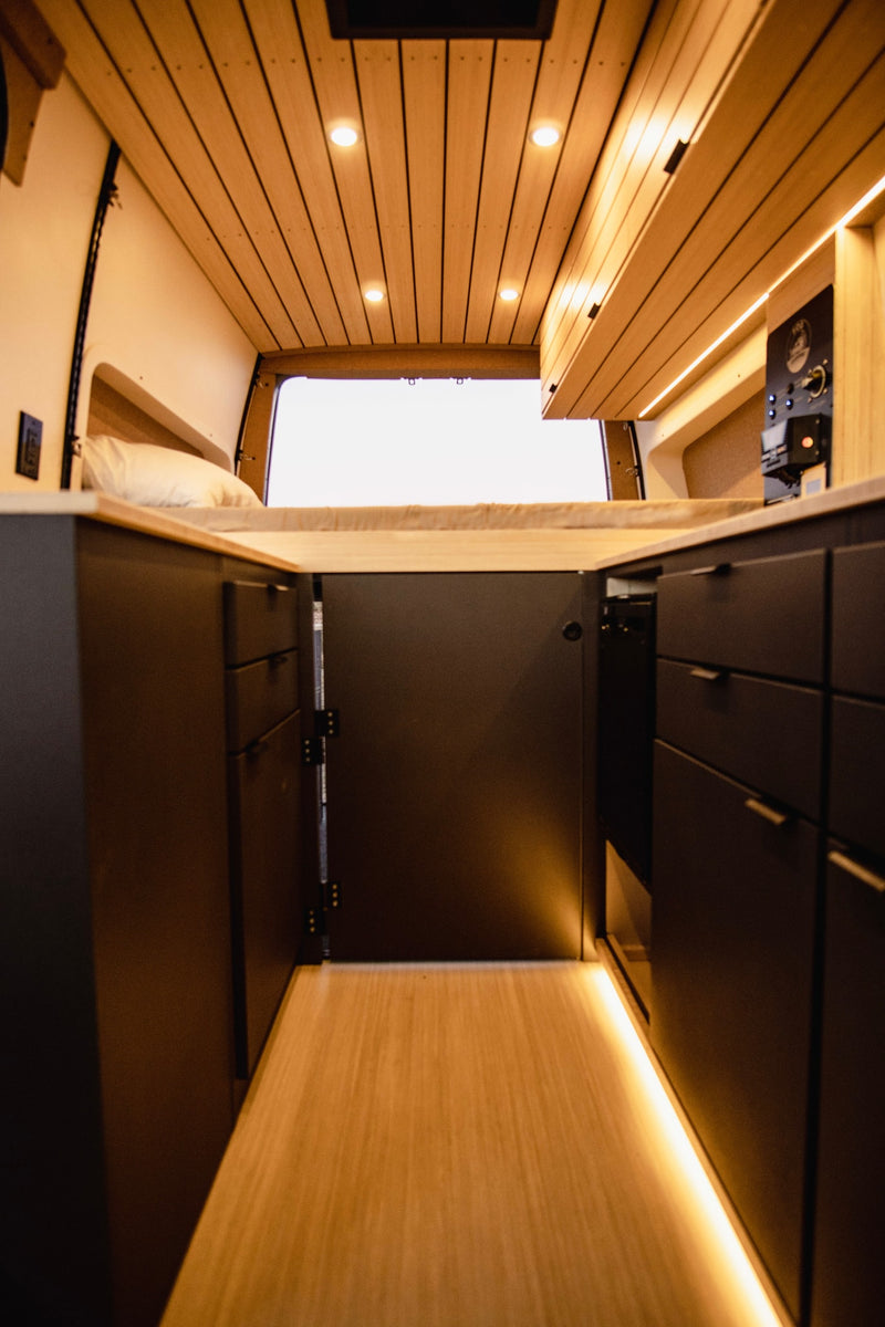  and a control panel for van systems.|A modern RV rental van under a clear sky — photo 8