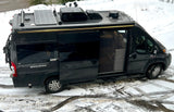 Sleek dark gray RV rental camper van, equipped for adventures with solar panels, AC, and a bike rack.