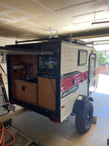 A compact Sunray Sport teardrop camper with an open rear kitchen, ready as an RV rental.