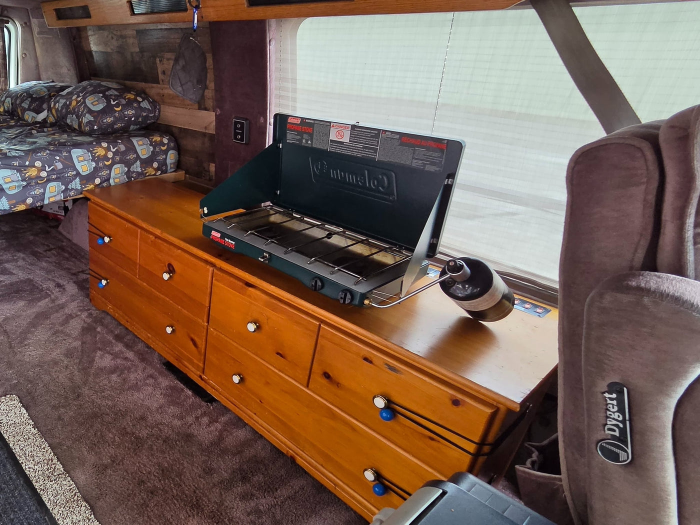  and wooden console.|Inside this classic RV rental: a Coleman propane stove — photo 9