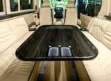 Spacious luxury rv rental interior featuring a large dark wood table and elegant cream quilted leather seating.