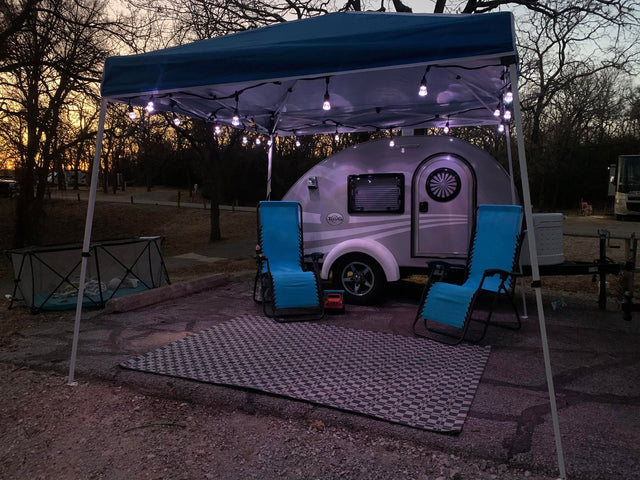 An|A cozy rv rental camping setup at night: a teardrop|Cozy RV rental campsite with a bright campfire