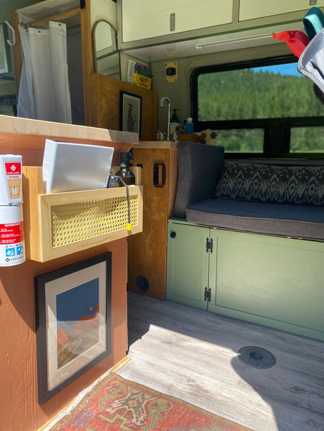 Cozy RV rental interior showcasing a compact kitchen, built-in seating, and wood accents. A bright, functional mobile space.