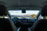 Inside an RV rental, a stunning mountain vista stretches through the windshield, visible from the front seats.