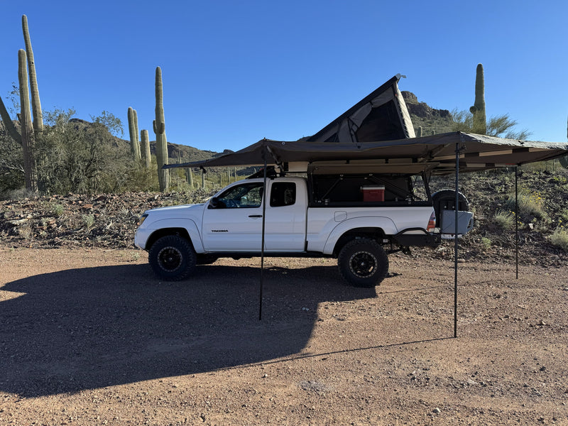 White Tacoma truck with rooftop tent & awning setup for desert camping, a unique RV rental experience awaits. — photo 3
