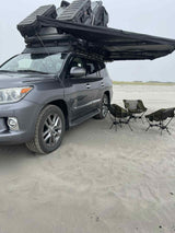 Lexus LX with rooftop tent & awning on a sandy beach. Ideal for overlanding adventures or a unique RV rental.