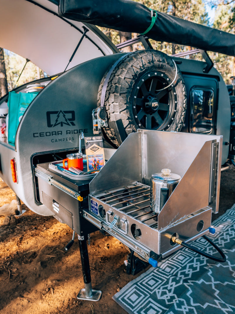 Cedar Ridge camper RV rental featuring a pull-out outdoor kitchen with a stove, coffee percolator, and sink. — photo 12