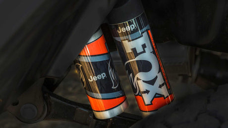 Detailed view of Jeep-branded FOX off-road shocks, displaying 'Internal Bypass' technology. Upgrade suspension for an adventurous rv rental!