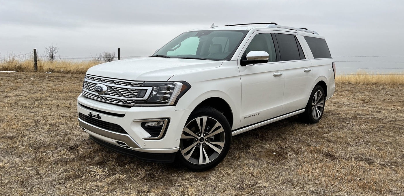 White Ford Expedition SUV, a large and comfortable vehicle in a field. Explore spacious travel options like an rv rental.