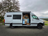 Explore in style with this light grey rv rental camper van, showcasing its open side door and modern interior with a kitchen.