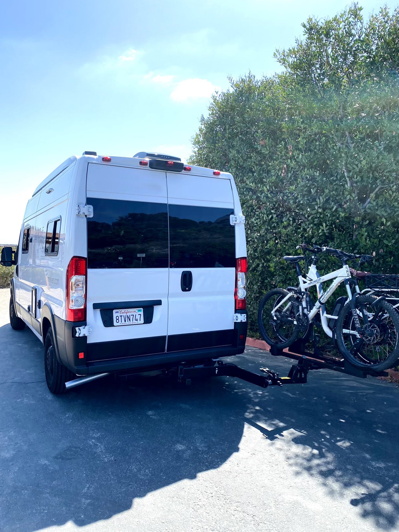 Rear view of a white RV rental van with a bike rack holding two mountain bikes, set for a road trip adventure. — photo 18