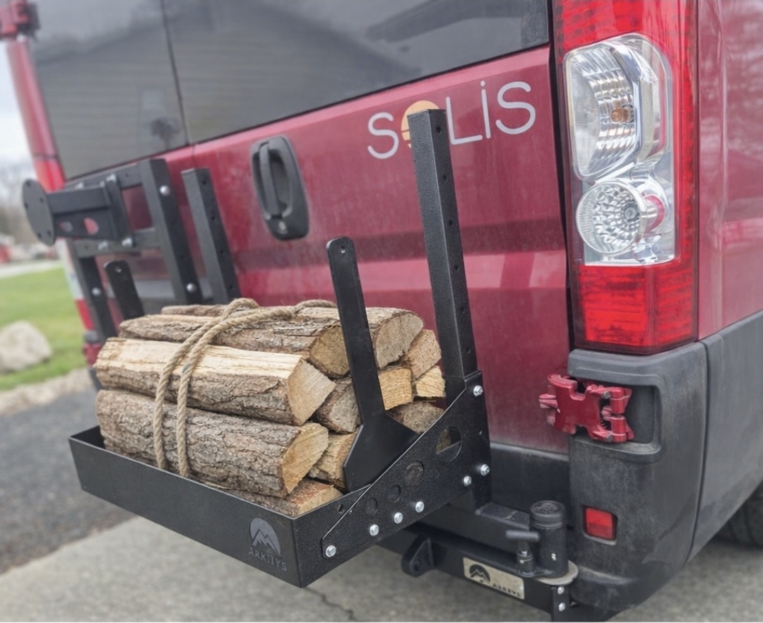Winnebago Solis RV rental van with rear-mounted Arktys cargo carrier packed with firewood, ready for adventure.