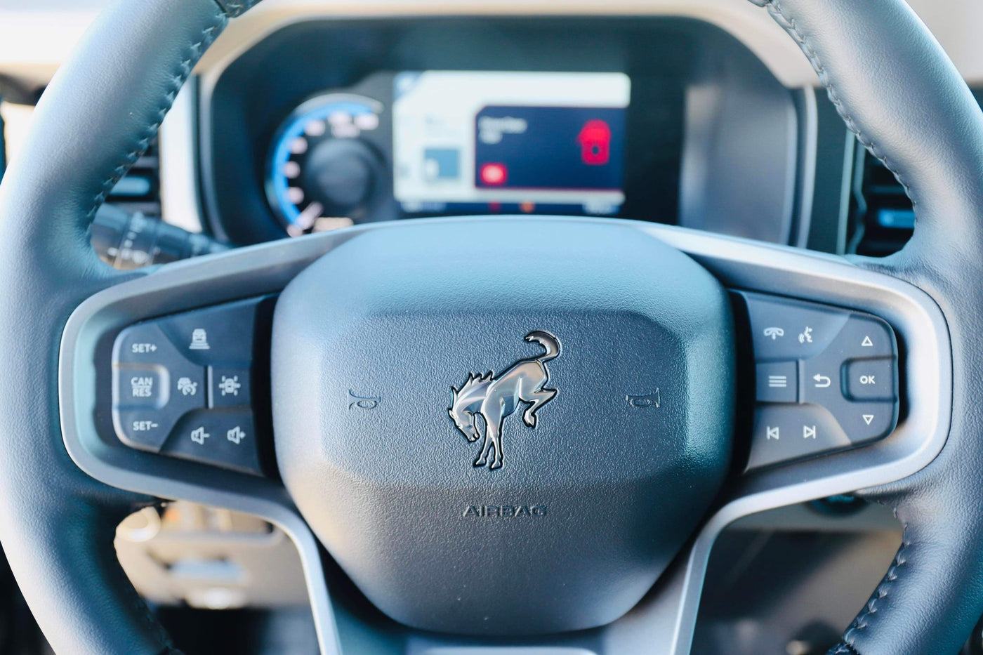 Detailed view of a modern Bronco steering wheel, showing controls and dashboard, perfect for your next rv rental journey. — photo 5