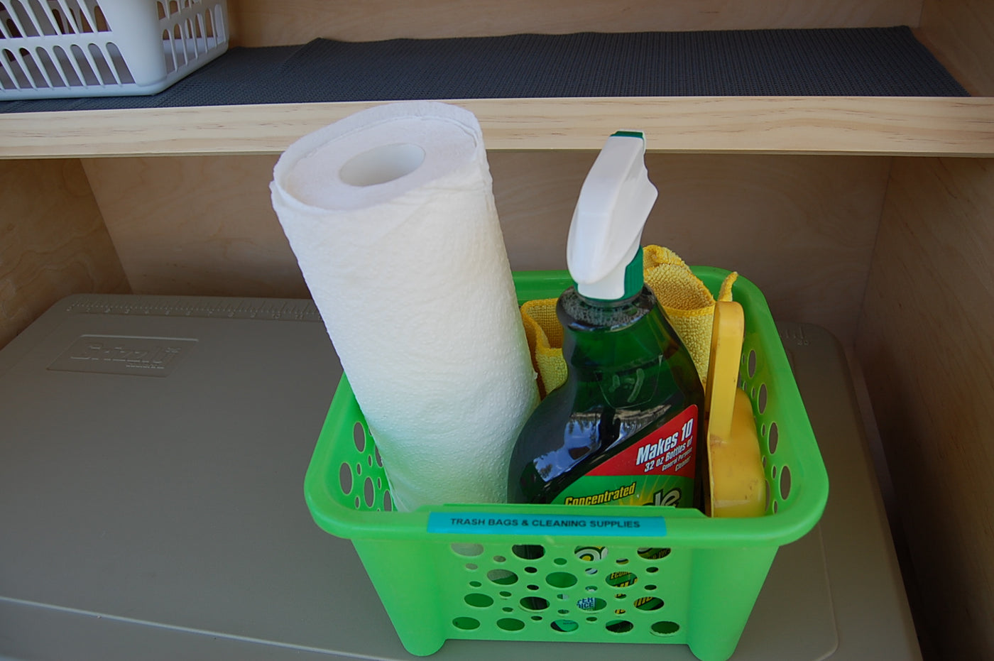 RV rental cleaning supplies: paper towels, spray cleaner, and rags in labeled green basket. Ready for spotless travel. — photo 10