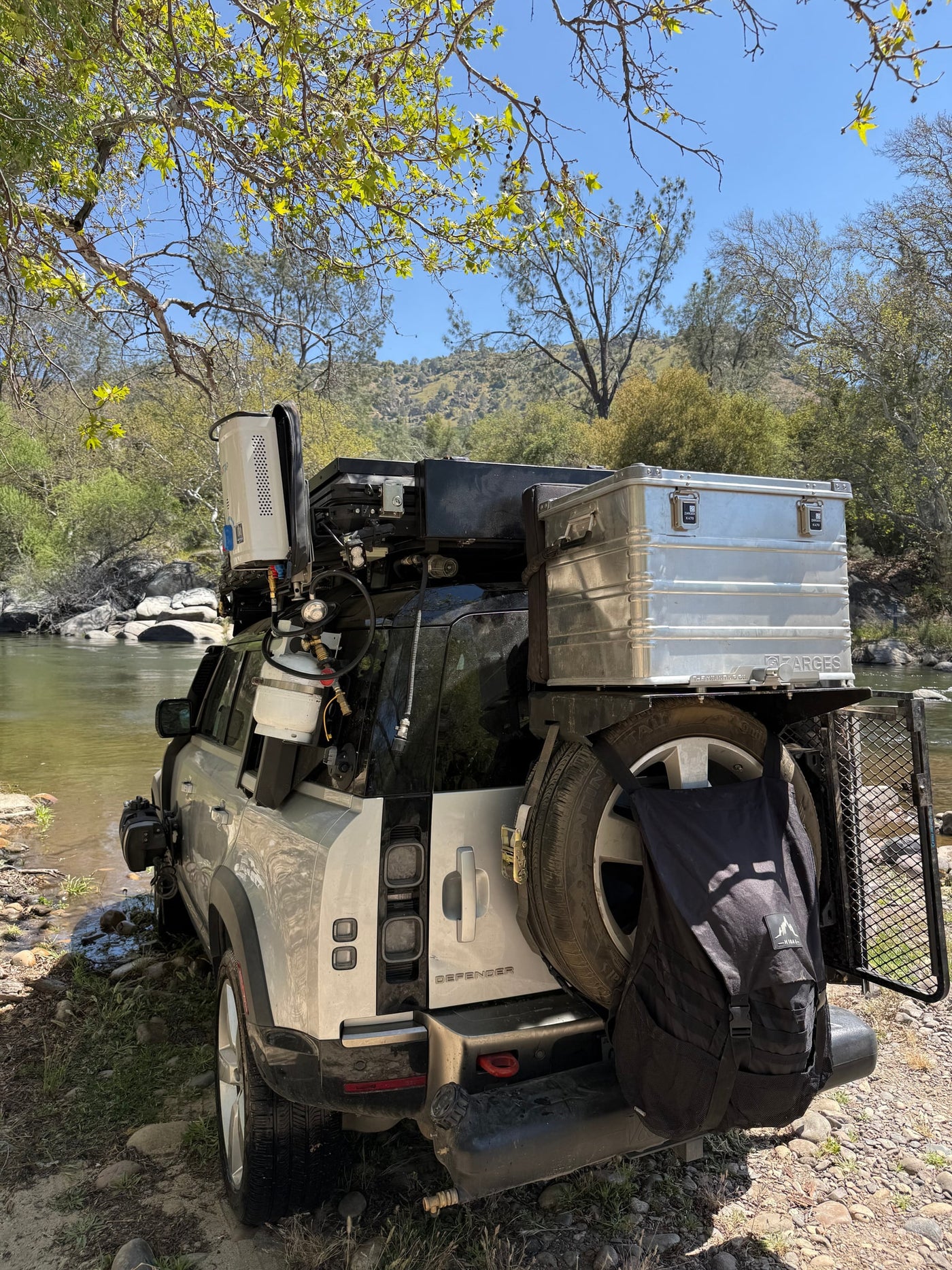Outfitted Land Rover Defender for RV rental overlanding, parked by a river. Perfect for off-grid adventure camping. — photo 7