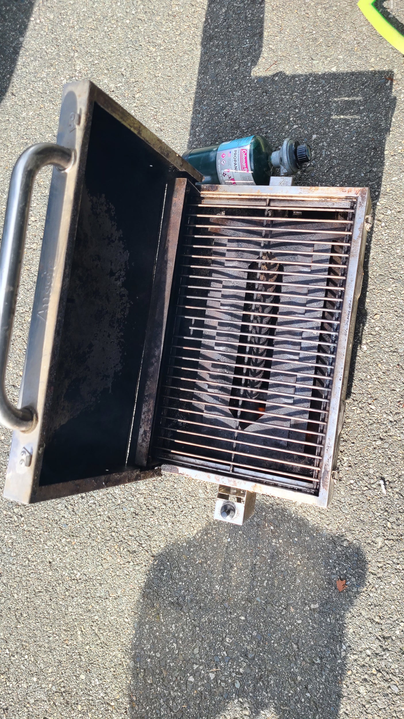 Portable propane grill with attached Coleman tank, ideal for outdoor cooking during your RV rental adventures.